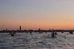 Barche a remi in corteo davanti a Murano e tramonto